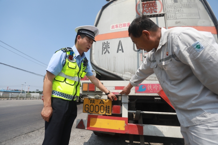 图为2020年7月9日，民警对危化品车辆的安全紧急切断装置进行检查